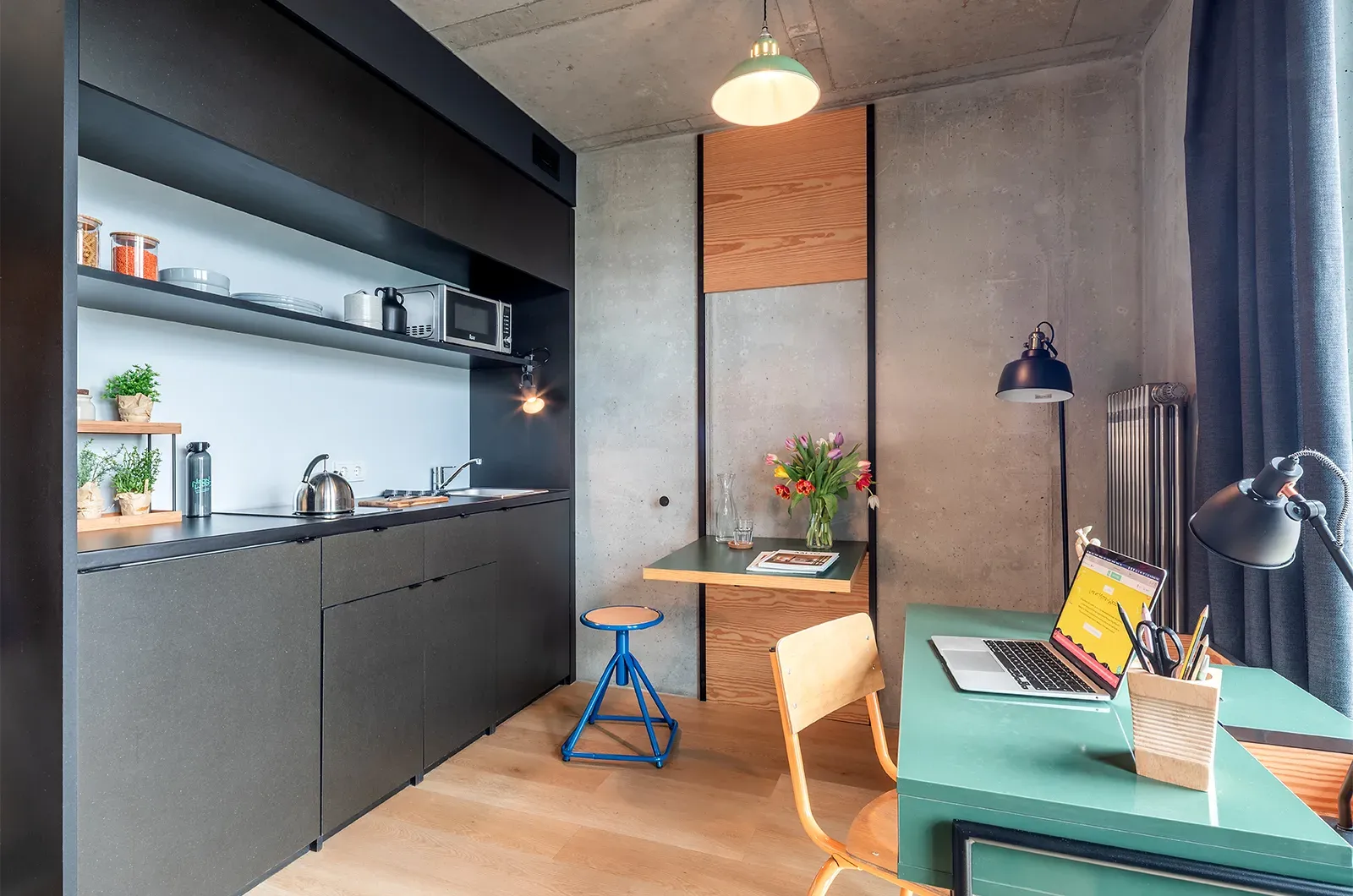 Styled kitchenette, foldable table and desk in a Deluxe Balcony Room at Neon Wood Berlin Mitte-Wedding showing decorated space and personalization example