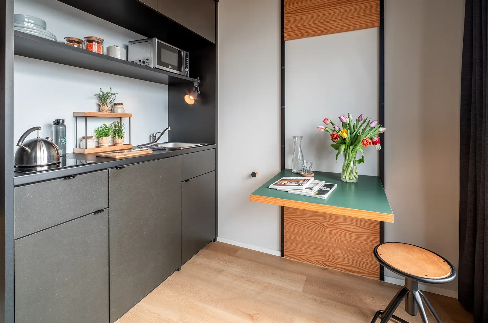 Styled kitchenette and foldable table in a Penthouse Room at Neon Wood Berlin Mitte-Wedding showing decorated space and personalization example