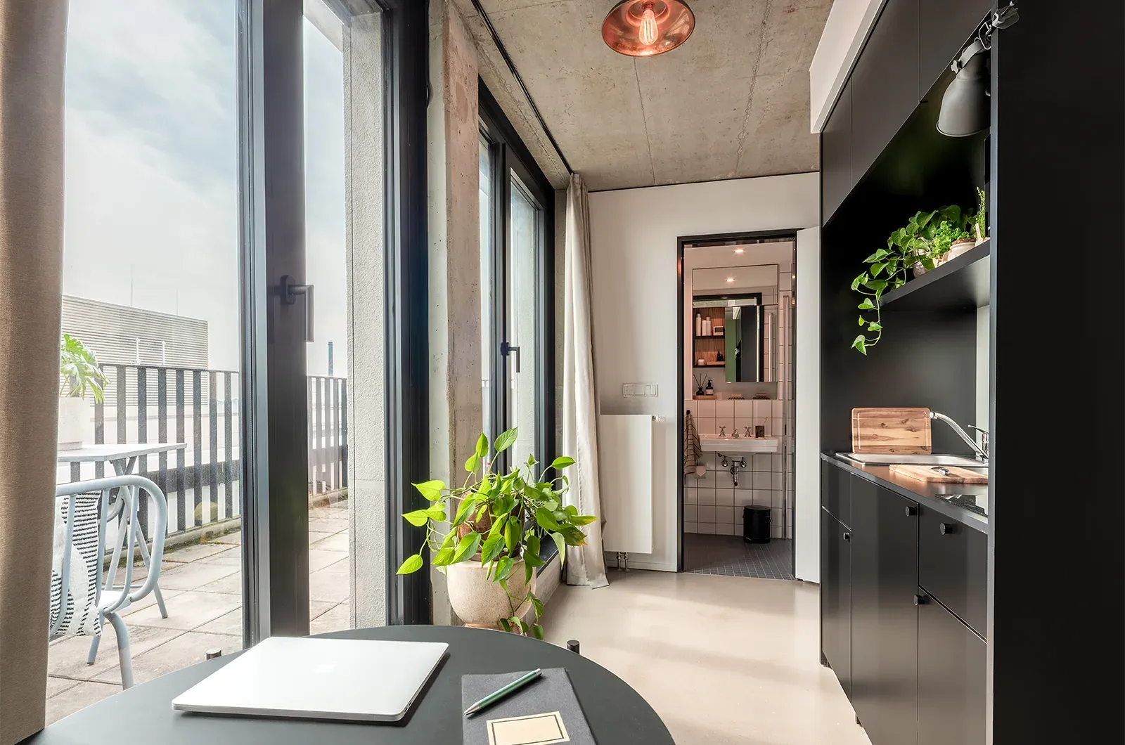 Styled view from the kitchen in a Penthouse Balcony Room at Neon Wood Frankfurt Riedberg showing decorated space and personalization example