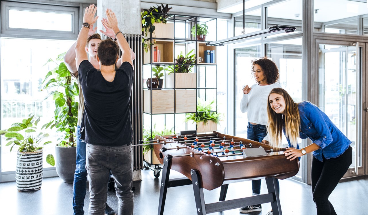 Students playing foosball in the Neon Wood Frankfurter Tor lobby — a student apartment with community spaces in Berlin